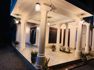 a building with columns and potted plants in a courtyard at The Layover Hostel in Katunayaka