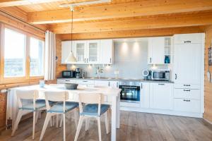a kitchen with white cabinets and a table and chairs at Strandhus Mira in Dahme