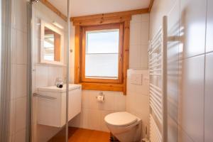 a white bathroom with a toilet and a window at Strandhus Mira in Dahme +19 photos