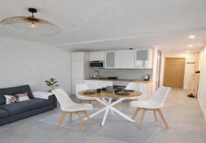 a living room with a couch and a table and chairs at Blue lagon-350m plage-clim-parking in Saint-Cyprien-Plage
