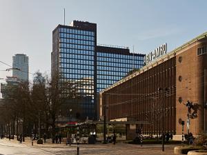 a city with tall buildings and people walking on a street at Numa Rotterdam Coolsingel in Rotterdam