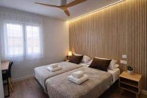 a bedroom with a large bed with two towels on it at Oak Lodge - Oakplaces in León