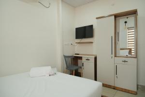 a bedroom with a bed and a desk and a television at The Varghese Beth in Munroe Island +23 photos