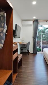 a room with a bed and a desk with a television at Sling & Stone Mountain Suites - Heritage House in Kampong Kundassan