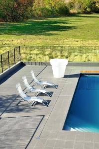 two chairs sitting next to a swimming pool at Relais Fasthotel Port Lauragais in Avignonet-de-Lauragais