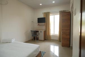a bedroom with a bed and a desk and a window at The Varghese Beth in Munroe Island