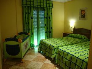 a hotel room with two beds and a chair at Hotel Lucero in Cuevas del Almanzora