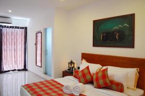 a bedroom with a bed with red and white pillows at Cafe Pinnalanda in Pinnawala