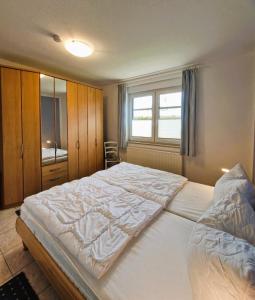 a bedroom with a large white bed with a window at Neue Liebe - Wohnung 1 in Groß Kirr