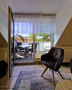 a living room with a chair and a view of a table at Neue Liebe Wohng_4 in Groß Kirr
