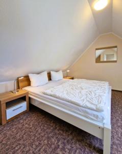 a bedroom with a white bed and a night stand at Neue Liebe Wohng_4 in Groß Kirr