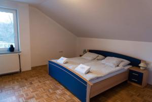 a bedroom with a bed with two pillows and a window at Goričko Homes in Mačkovci