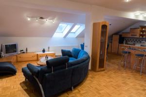 a living room with two blue couches and a kitchen at Goričko Homes in Mačkovci