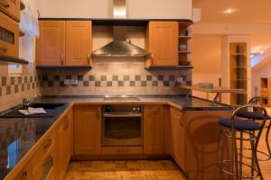 a kitchen with wooden cabinets and a stove top oven at Goričko Homes in Mačkovci