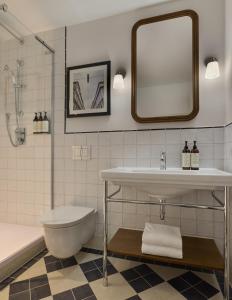 a bathroom with a sink and a toilet and a mirror at Miiro Spittelberg NEW OPENING in Vienna +77 photos