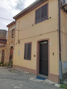 a building with a black door on the side of it at In Sardegna da Anna Rita in Scano Montiferro