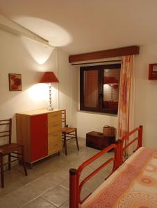 a bedroom with a bed and a dresser and a window at In Sardegna da Anna Rita in Scano Montiferro