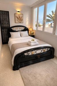 a bedroom with a large bed with a large window at La Perle de Hergla Maison d Hotes in Harqalah
