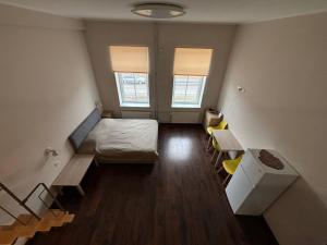 a bedroom with a bed and a desk and two windows at Apartments near Noblessner in Tallinn