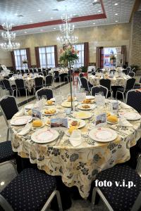 une salle à manger avec une table et des assiettes de nourriture dans l'établissement Hotel Acosta Ciudad de la Música, à Villafranca de los Barros