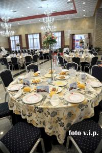 a dining room with a table with plates of food at Hotel Acosta Ciudad de la Música in Villafranca de los Barros