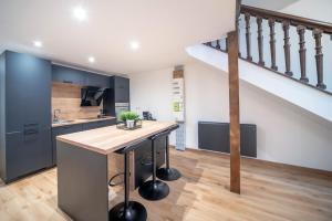 a kitchen with a island in a kitchen with a staircase at Myappart71- Loft - centre ville in Mâcon