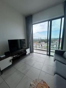 a living room with a television and a large window at PeaceStay in Sandakan