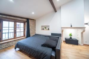 a bedroom with a bed and a brick wall at Myappart71- Loft - centre ville in Mâcon