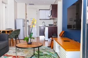 a kitchen and living room with a table and a couch at Umhlanga Apart Hotel in Durban