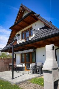 a house with a balcony and a table and chairs at Magia Gór -500m do Gorący Potok i Term Szaflary-rabaty in Szaflary