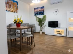 a dining room with a table and chairs and a tv at Central Suite - Premium Villas in Giulianova
