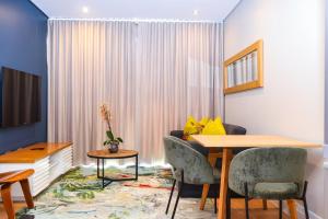 a dining room with a table and chairs and a window at Umhlanga Apart Hotel in Durban