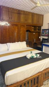 a bedroom with a large bed with wooden cabinets at Thanal Home Stays in Kollam