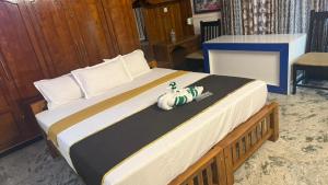 a bed with a stuffed animal sitting on top of it at Thanal Home Stays in Kollam +1 photo