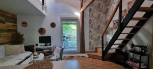 a living room with a staircase and a couch at Maison Oscar et Petrus in Beaumont-du-Gâtinais