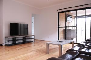 a living room with a couch and a tv at Sweet Home Property Forrestfield in Perth
