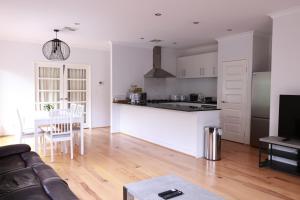 a kitchen and living room with a couch and a table at Sweet Home Property Forrestfield in Perth