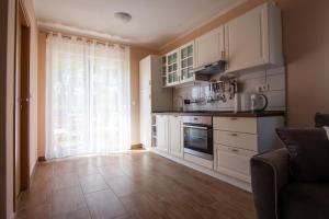 a kitchen with white cabinets and a large window at Apartments Slavek in Jastrebarsko