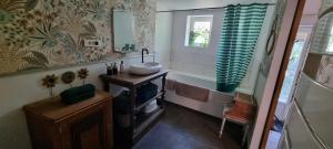 a bathroom with a sink and a tub and a mirror at Maison Oscar et Petrus in Beaumont-du-Gâtinais +20 photos