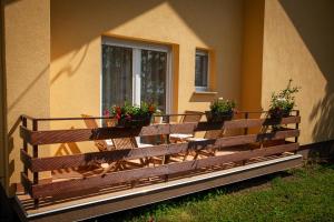 a wooden bench with potted plants on the side of a building at Apartments Slavek in Jastrebarsko