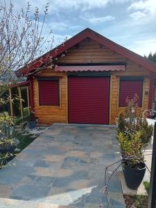 a house with two red garage doors on it at Chalet d'Art in Saint-Georges