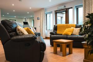 a living room with two couches and a table at Lakeside Lodge, Views, Hot Tub & Fully Accessible in Elgin