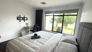 a bedroom with a bed and a large window at Sweet Home Property Forrestfield in Perth