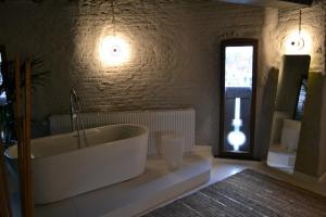een grote badkamer met een bad en een raam bij De Pelsertoren in Zwolle +37 foto's