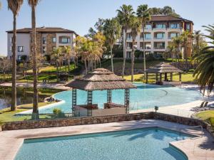 a swimming pool with a gazebo and a building at Sofitel La Reserva Cardales in Río Luján