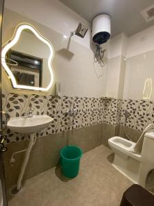 a bathroom with a sink and a toilet and a mirror at Rudravasa Inn in Varanasi +18 photos