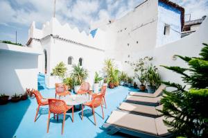 a patio with chairs and tables on a white building at Dar Jiblia in Chefchaouen