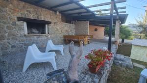 a patio with two white chairs and a table at House Anastazia Pool & Panoramic Sea View in Lovran