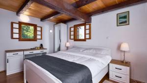a bedroom with a large white bed with wooden ceilings at Villa 77 by Villas Guide in Sisak