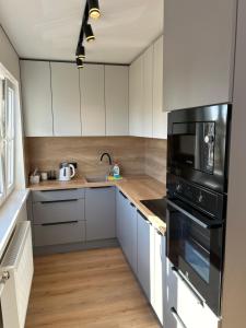 a kitchen with white cabinets and black appliances at Апартаменты Toome в Кохтла-Ярве in Ahtme